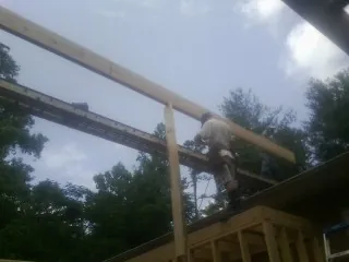 Carpenter setting a ridge beam over a new addition frame — Ice Dam Removal by Roofing Brothers in Nellysford