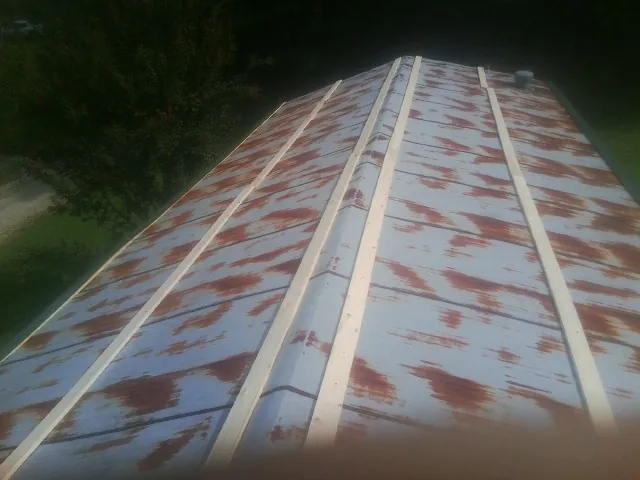 Rusted metal roof panels with new wood purlins before replacement — Storm Damage Roof Repair in Nellysford by Roofing Brothers