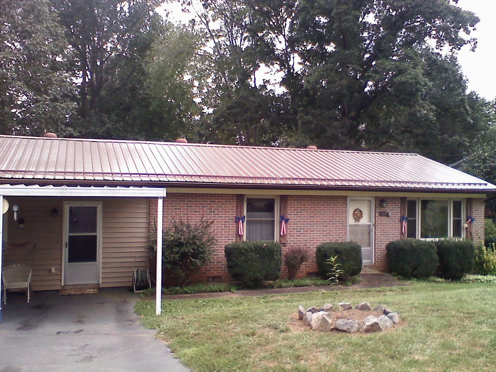 Bronze metal roof and carport on a brick ranch home — Roof Repair work by our crew in Nellysford
